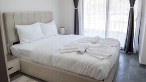 A neatly made bed with white linens, a bedside table with a lamp, and a window with curtains. - Lale Saray - Sapanca (Sapanca)