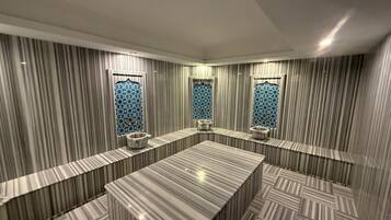 A modern bathroom with a central marble sink, two vanity mirrors, and patterned walls.