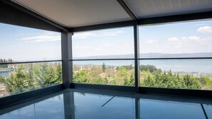 A room with large windows offering a view of a lake and surrounding greenery. - Lale Saray - Sapanca (Sapanca)