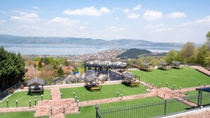 A park with green lawns, wooden gazebos, and a view of a lake and distant hills. - Lale Saray - Sapanca (Sapanca)