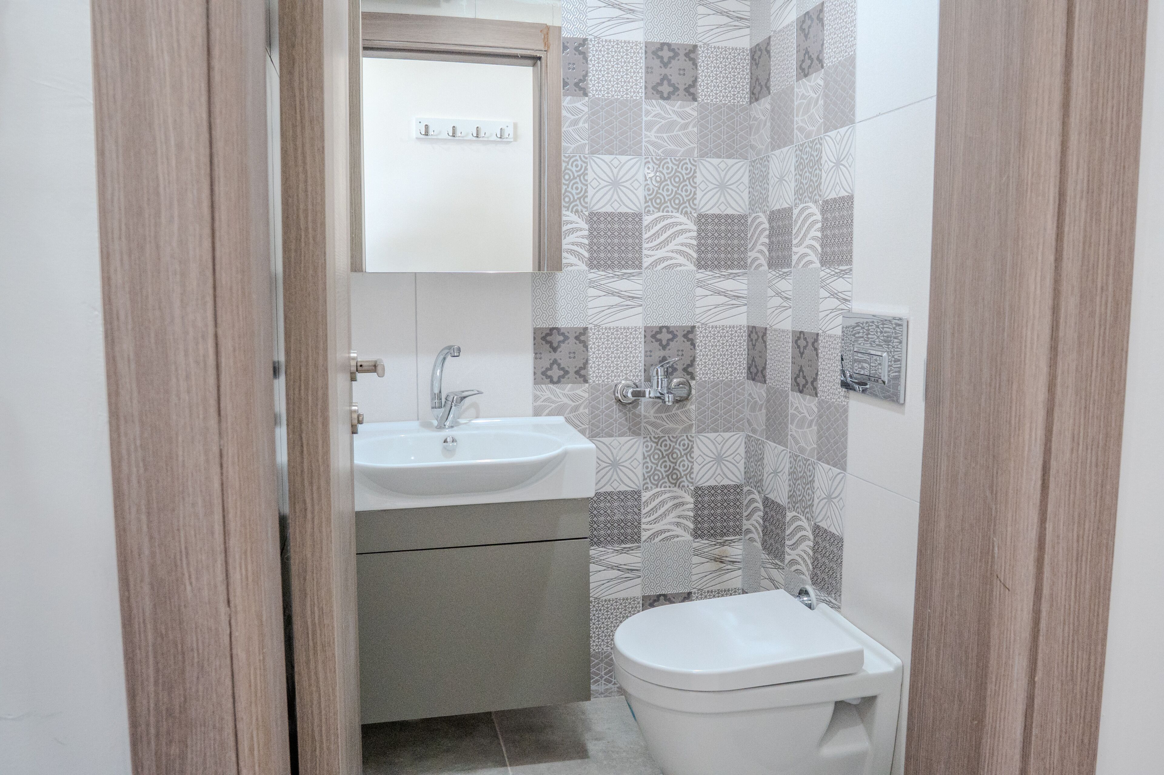 Un baño pequeño con lavamanos, inodoro y un espejo sobre el lavamanos.