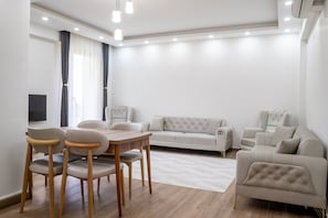 A modern living room with a dining table, chairs, sofas, and a flat-screen TV. - Lale Saray - Sapanca (Sapanca)