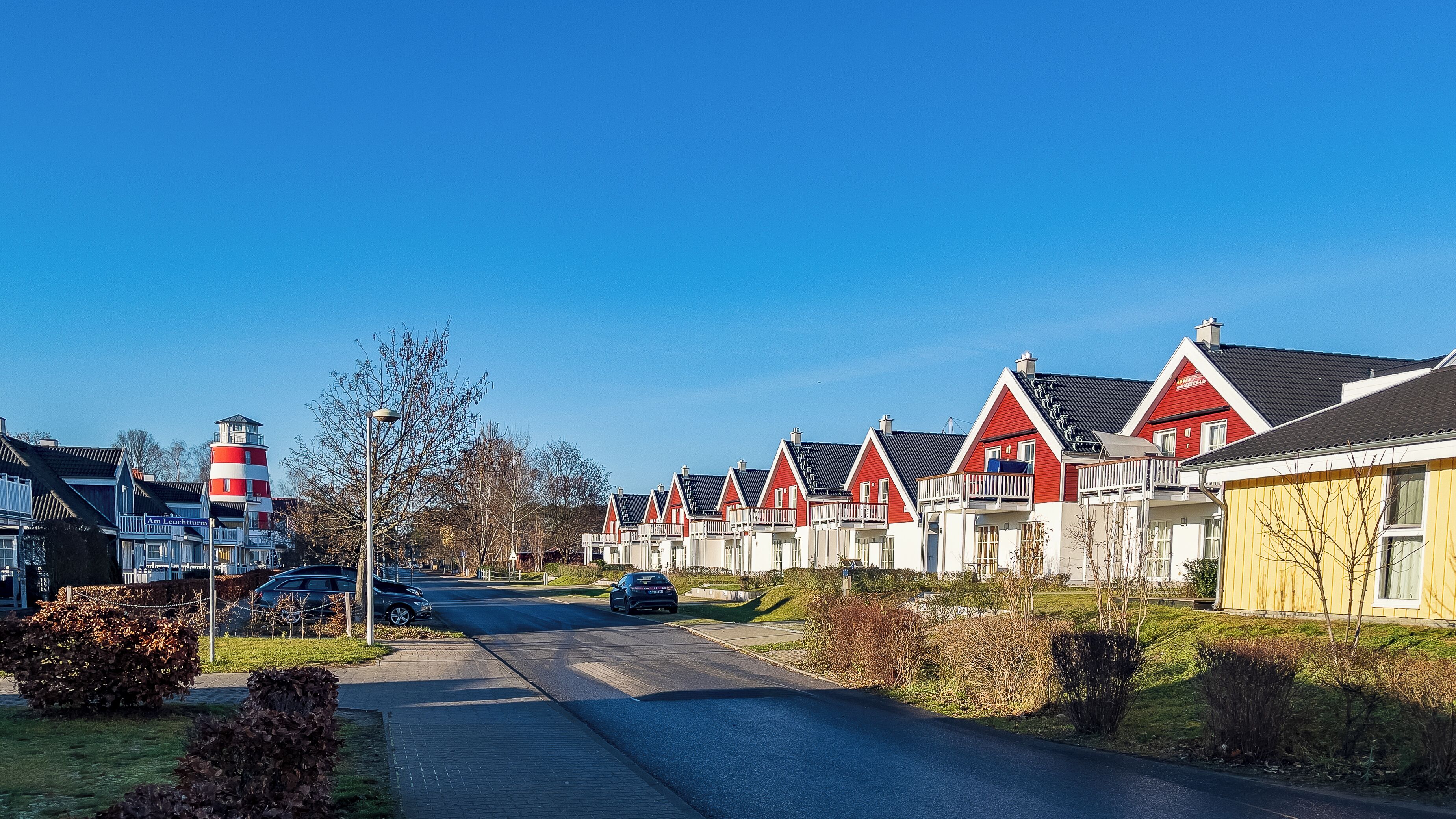 Une rangée de maisons rouges et blanches, avec un ciel dégagé.