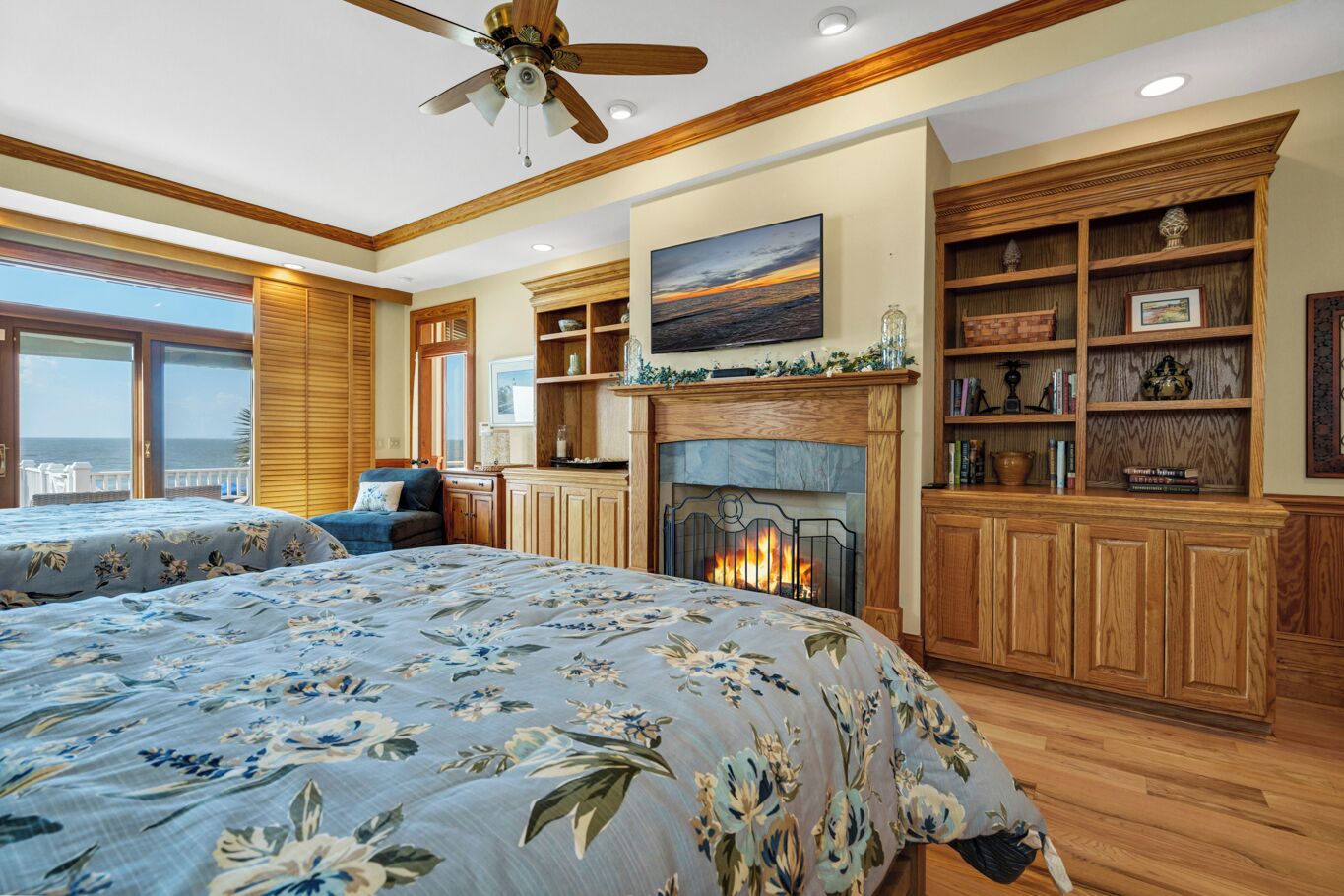 Une chambre avec une cheminée, des meubles en bois et une vue sur l’océan.