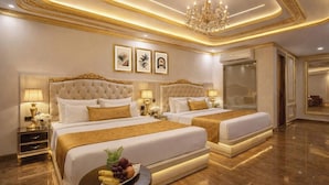 A luxurious hotel room with a large bed, two bedside tables, a chandelier, and framed artwork on the wall. - Hotel Urban Lion - Delhi Airport (New Delhi)