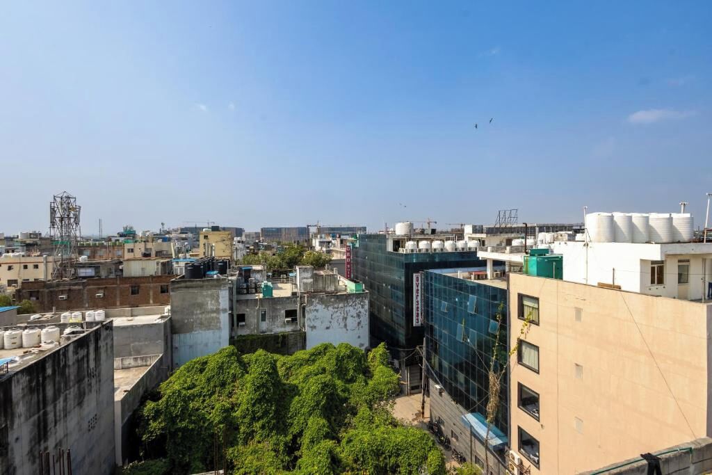 A cityscape with buildings, some with water tanks on rooftops, and a clear sky.