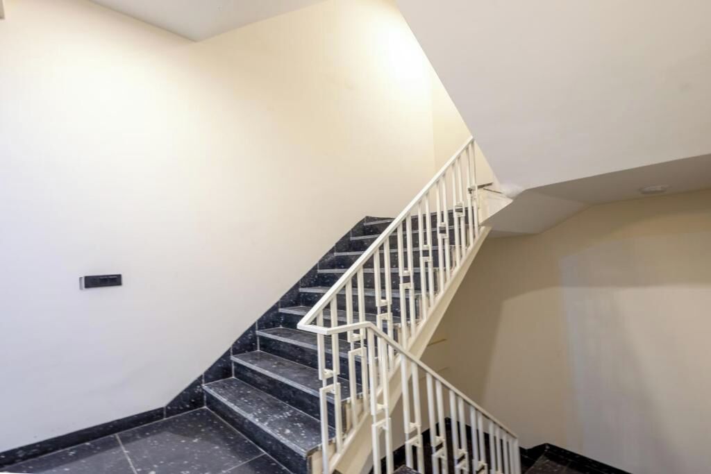 Un escalier avec des marches en marbre noir et des rampes blanches.