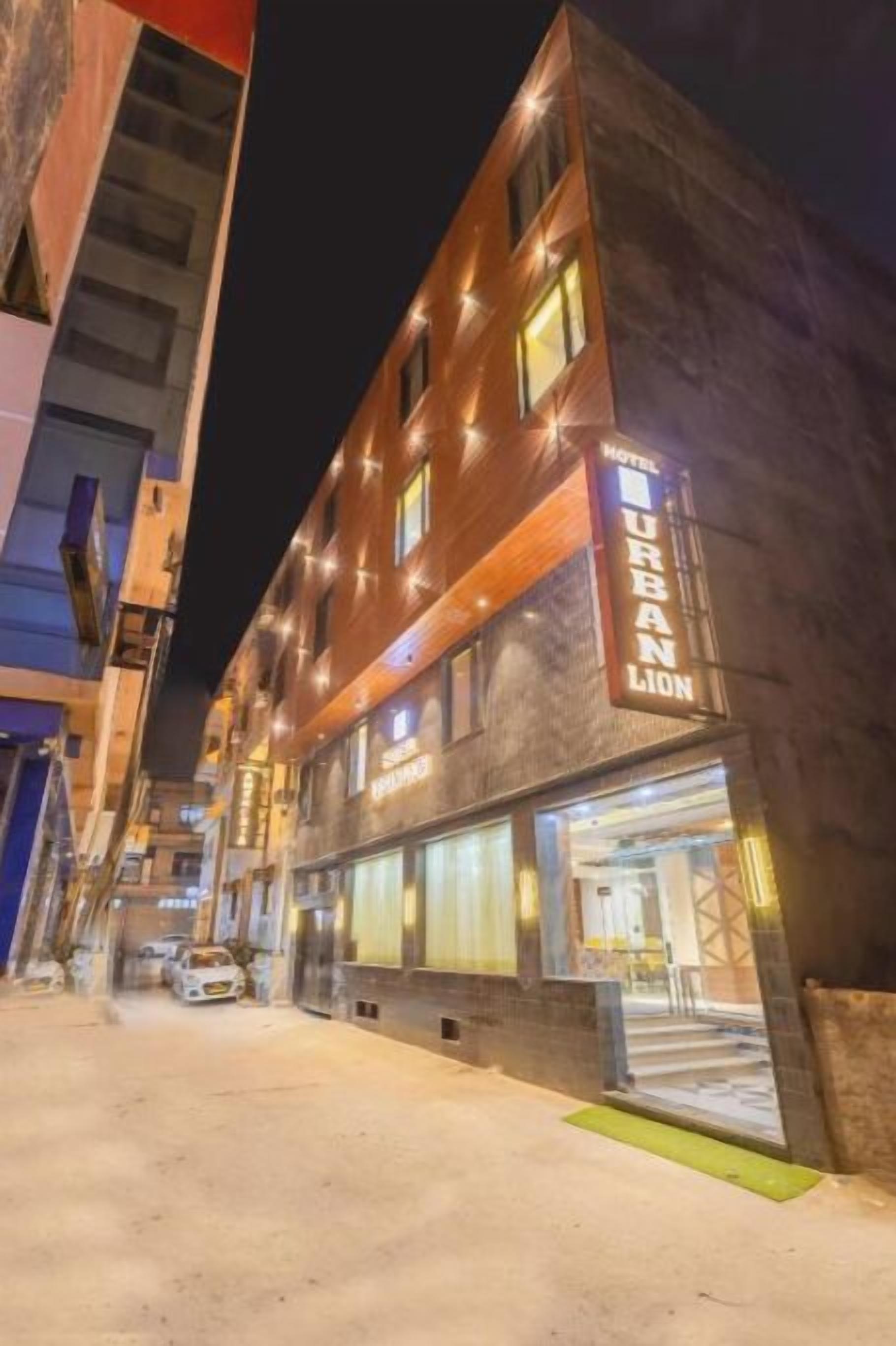 A hotel named 'Urban Lion' with a modern facade, large windows, and a visible entrance.