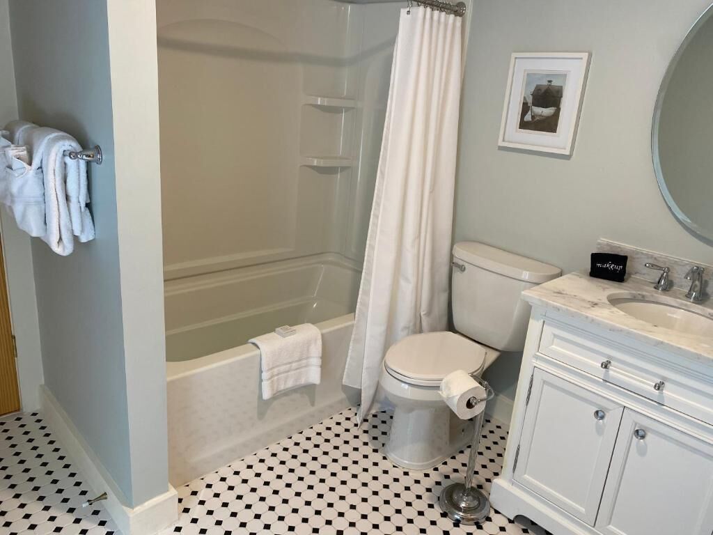 A bathroom with a bathtub, toilet, and sink.