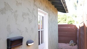 Ein Haus mit Briefkasten, einer Tür und einem umzäunten Hinterhof.
