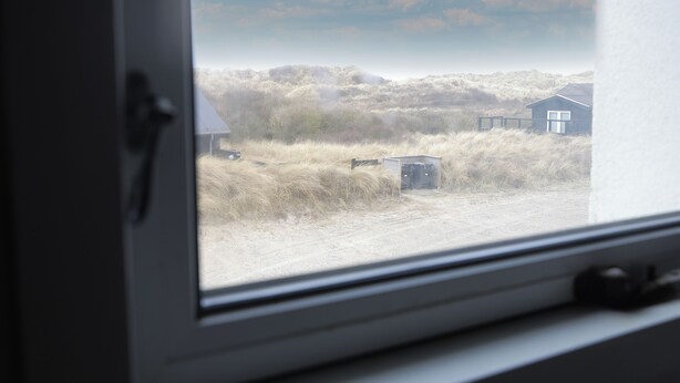 Blick aus dem Fenster auf eine ländliche Landschaft mit einem Haus und einem kleinen Schuppen.
