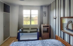 A bedroom with a bunk bed, a desk, a chair, a window with a view of greenery, and a framed picture on the wall. - Cozy home in RUMINGHEM with WiFi (RUMINGHEM)