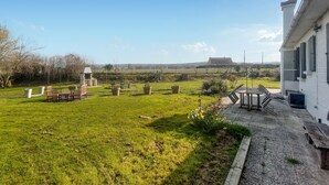 A grassy outdoor area with a picnic table, benches, and a small structure. - Cozy home in RUMINGHEM with WiFi (RUMINGHEM)