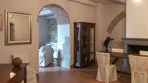Una habitación con chimenea, un aparador de madera y una mesa de comedor con sillas.