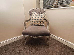 A chair with a floral cushion in a corner with a window. - Marina Side (Whitby)