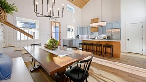 A spacious kitchen with a central island, wooden flooring, and a high ceiling with exposed beams. - Pickleball, Pool, Splash Fountain ,Clubhouse , Walking Trails , Basketball (Broken Bow)