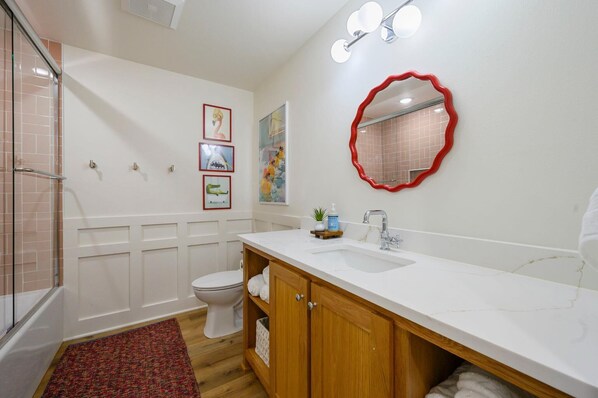 A bathroom with a shower, toilet, vanity with a sink, and a mirror. - Pickleball, Pool, Splash Fountain ,Clubhouse , Walking Trails , Basketball (Broken Bow)
