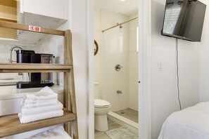 A bathroom with a shower, toilet, and a TV mounted on the wall. - Dog-friendly Unit w/ Pool Access in Pompano Beach! (Pompano Beach)
