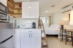 A compact kitchen with a microwave, coffee maker, and a small refrigerator. There is a bed with a wooden ladder and a table with chairs. - Dog-friendly Unit w/ Pool Access in Pompano Beach! (Pompano Beach)
