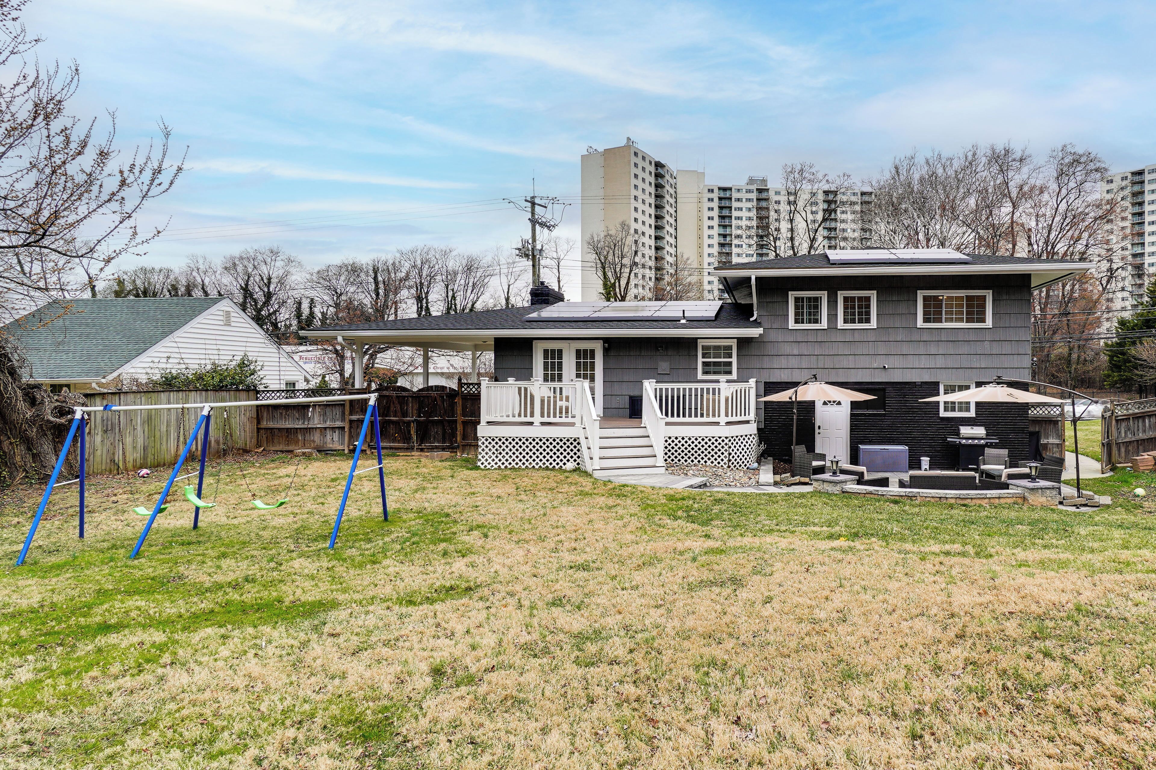 A residential house with a deck, a barbecue area, and a fenced yard.