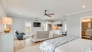 Ein Schlafzimmer mit Bett, Schreibtisch, Stuhl, einer Couch und einer Küchenzeile.