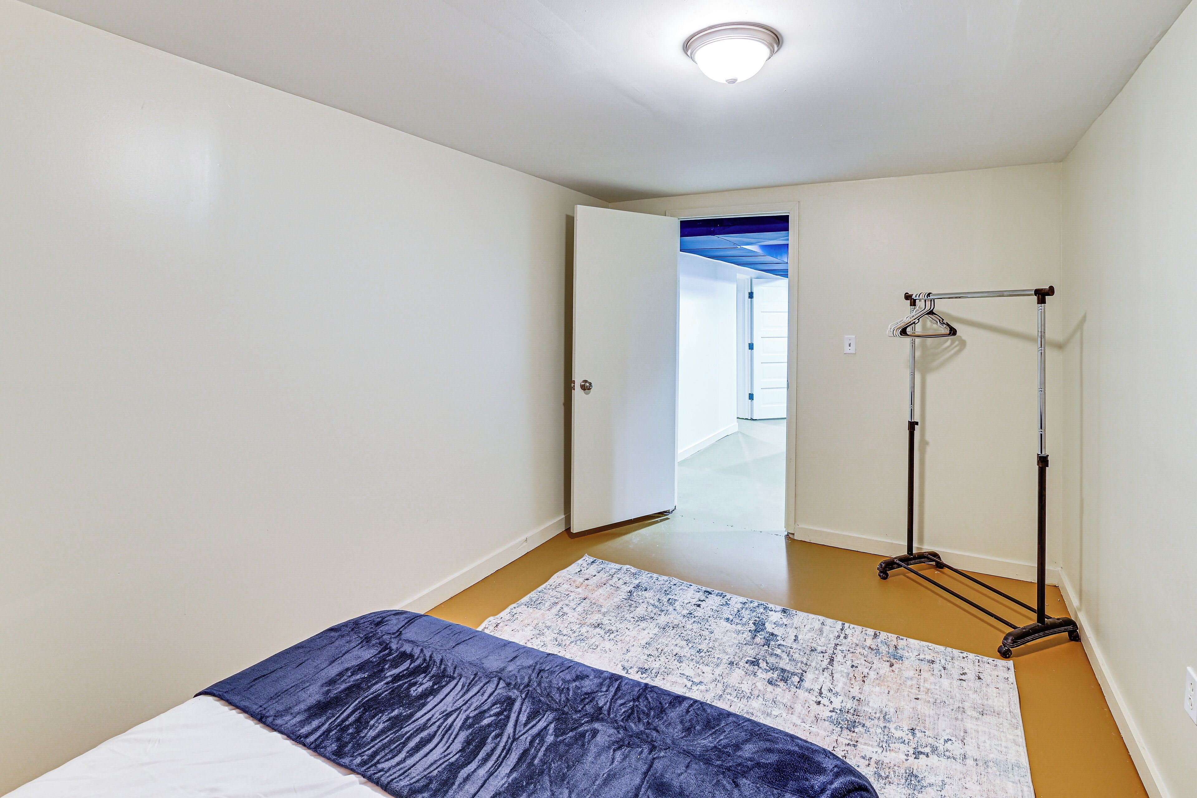 Ein Schlafzimmer mit einem Bett, einer Stehlampe und einer Tür zu einem anderen Raum.