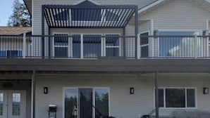 A two-story house with a covered balcony, sliding glass doors, and outdoor furniture. - 2 Mi to Lake Coeur Dalene! Serene Retreat, Patio (Coeur d'Alene)