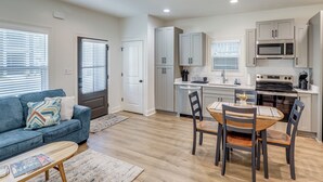 A modern kitchen with white cabinets, a microwave, and an oven.