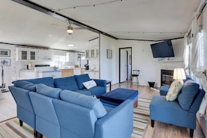 A modern living room with a sectional sofa, a small ottoman, and a fireplace.