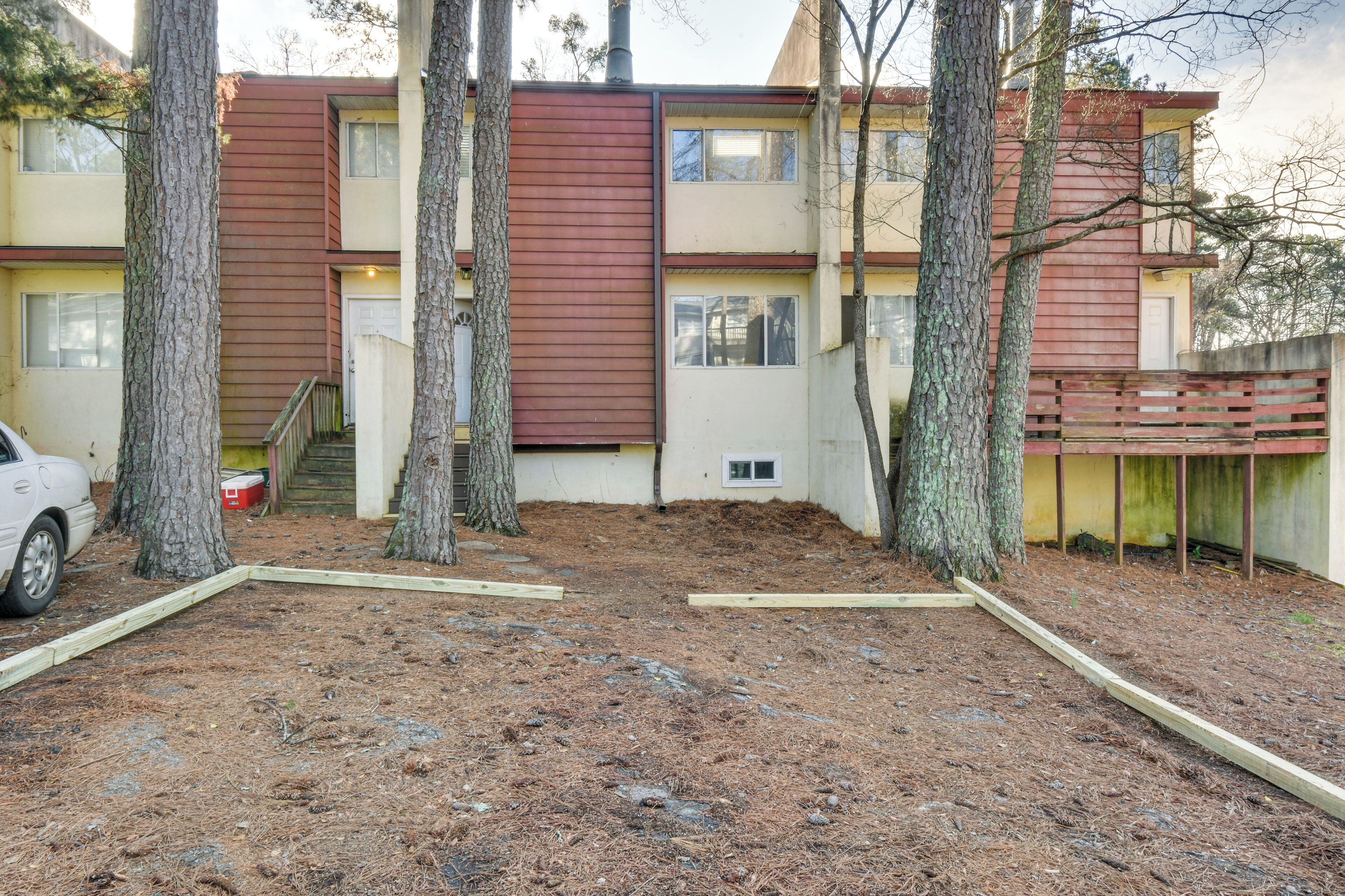 A multi-story building with a red and beige exterior, surrounded by trees.