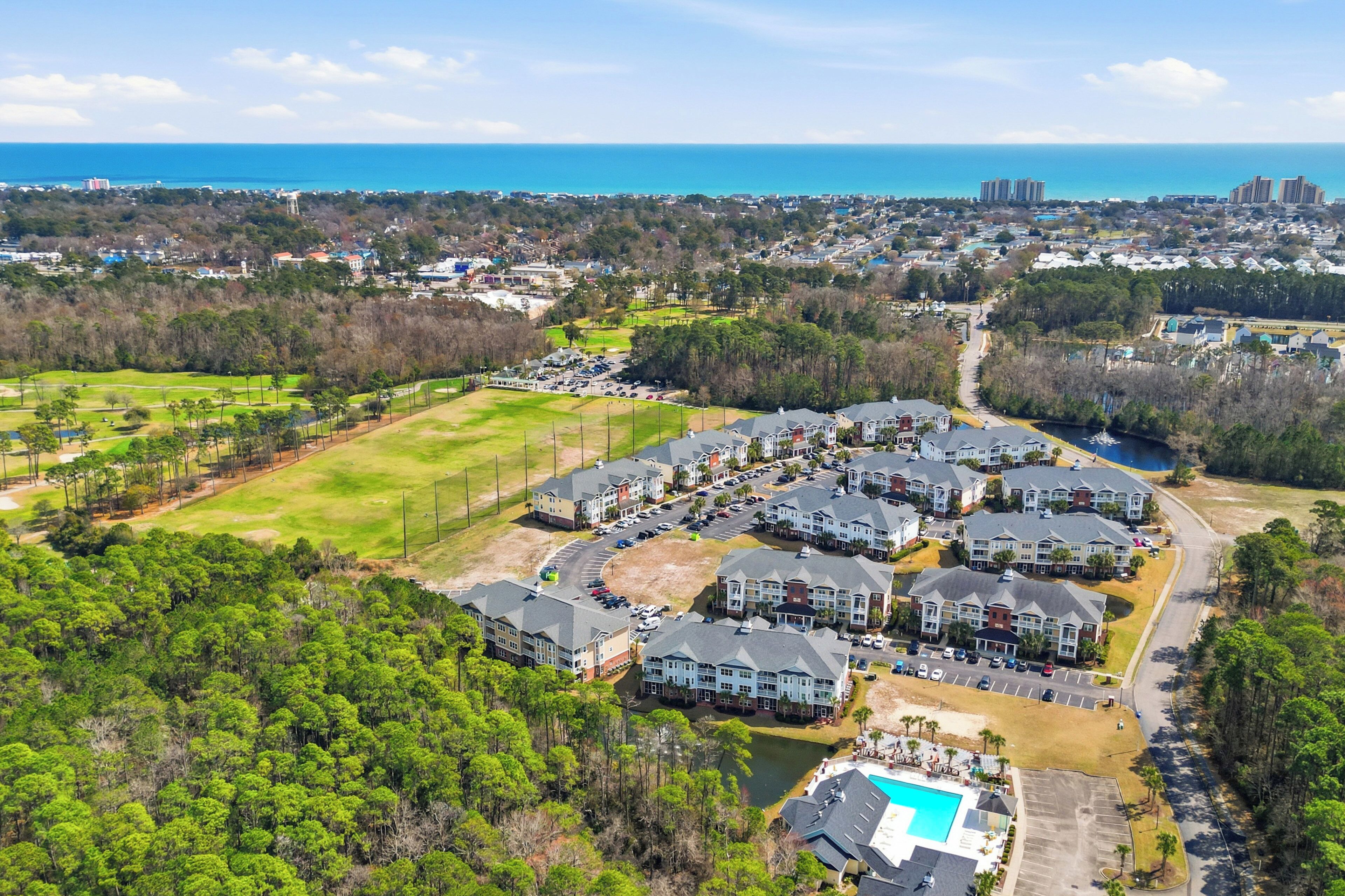 Zona residencial com edifícios de apartamentos, piscina e vista para o oceano.