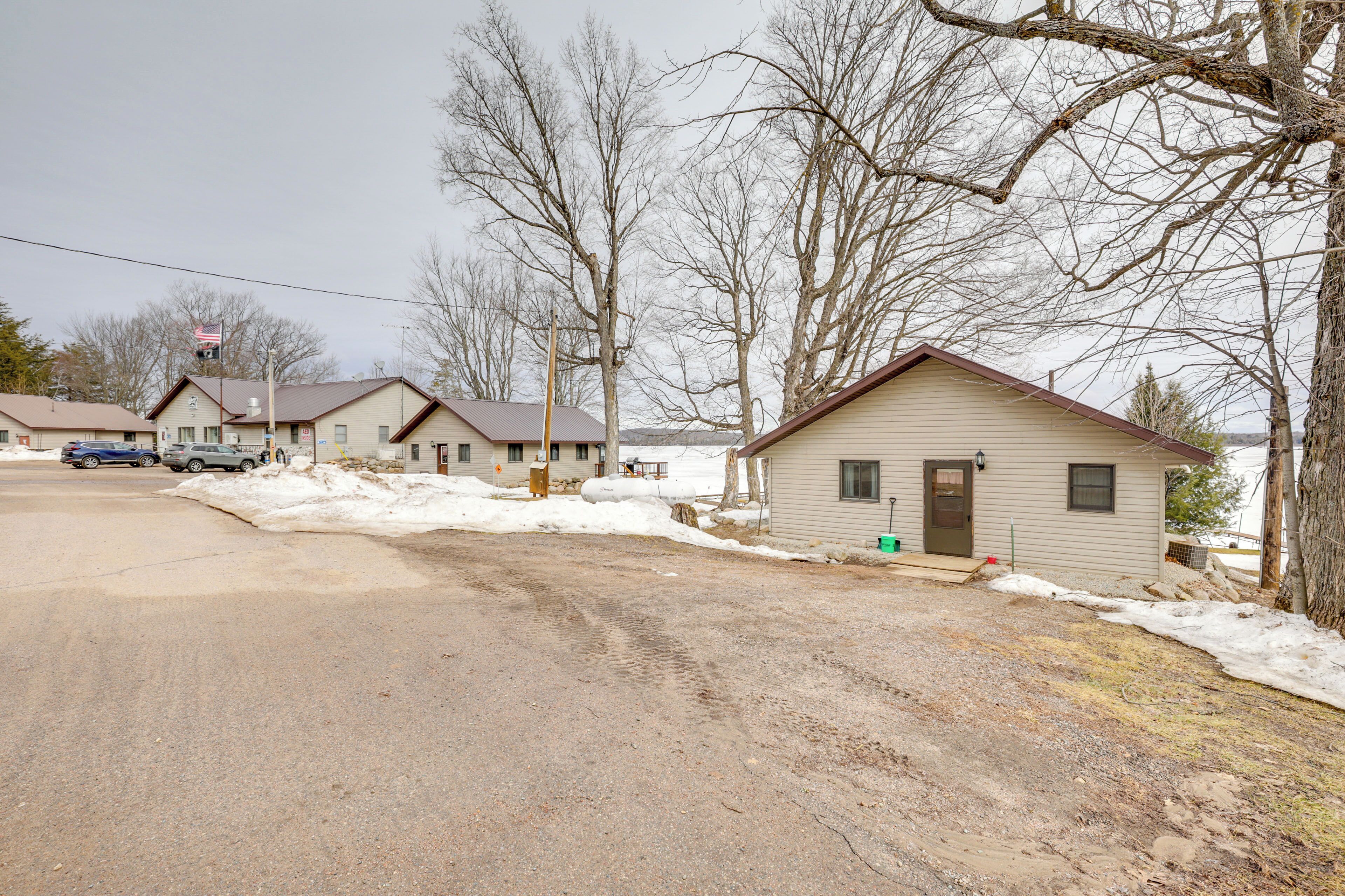 A residential area with houses, a road, and bare trees.