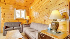 Un intérieur en bois avec un canapé, une table et une lampe.