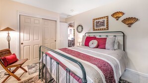 A bedroom with a bed, a chair, a lamp, and a door. - Rustic Mtn-view Home w/ Wood Stove: Dog Friendly (Felton)