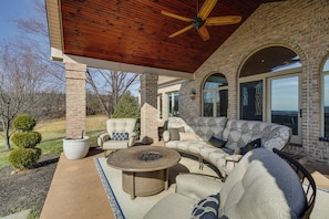 A covered patio with a brick wall, outdoor furniture, and a ceiling fan. - Great for Groups! Luxe + Private Myersville Estate (Myersville)