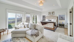 Une chambre spacieuse avec un grand lit, un canapé et une vue sur l’extérieur.