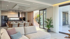 Un salon moderne comprenant un canapé, un coin repas et une cuisine.