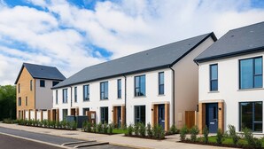 A row of modern townhouses with a flat roof, large windows, and a well-maintained front garden. - Room-cozy & Peaceful Retreat Near Dublin (Cappagh)