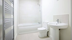 A modern bathroom with a bathtub, toilet, and sink. - Room-cozy & Peaceful Retreat Near Dublin (Cappagh)