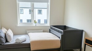 A room with a bed, a window, and a view of buildings outside. - Room-cozy & Peaceful Retreat Near Dublin (Cappagh)