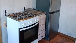 A compact kitchen with a gas stove, oven, and a refrigerator.