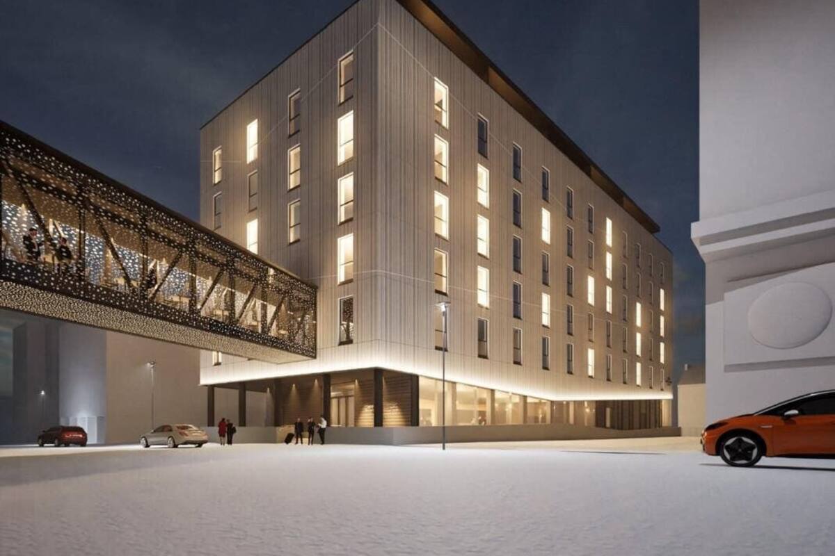Un edificio moderno con tetto piatto, ampie finestre e un'area d'ingresso coperta.