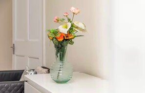 A clear view of a room with a white door, a white table, and a glass vase with flowers. - 2-bed Apartment in Morningside - by Holiday Homes (Edinburgh)