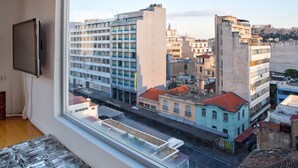 Un edificio de gran altura con varios pisos, un televisor de pantalla plana montado en la pared y vistas de la ciudad a través de una ventana.