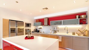 Una cocina moderna con electrodomésticos de acero inoxidable, una isla central y una pared de acento roja.