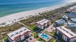 Vista aérea de un hotel costero con varias construcciones, una piscina y una playa.