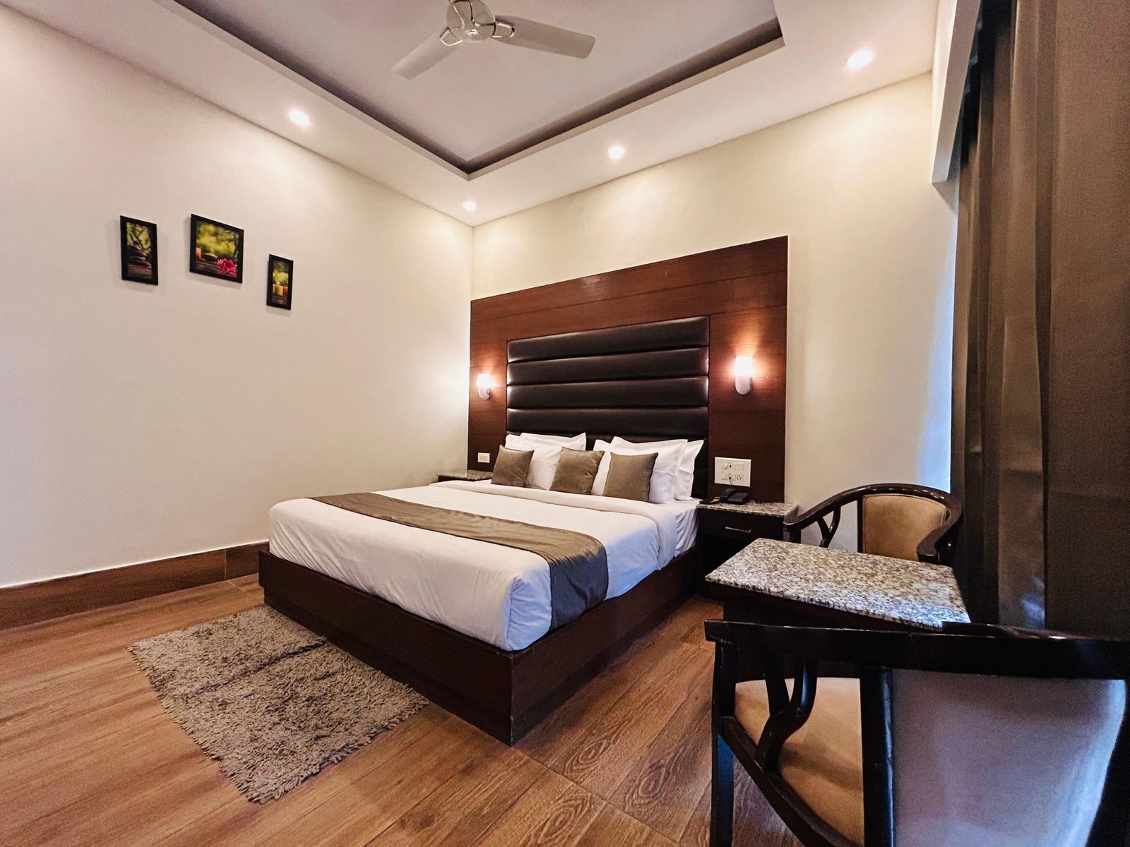 A modern hotel room with a large bed, a desk, and a chair.