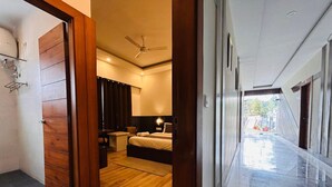 A hotel room with a bed, bedside table, and a ceiling fan.