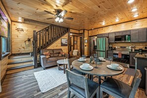 Un intérieur en bois comprenant un coin repas, une cuisine et un escalier.