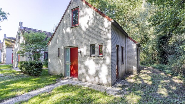 A small, single-story brick house with a red door and a chimney. - Lakeside Sauna Bungalow for 4 (Ewijk)